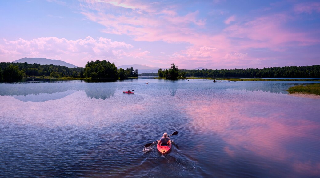 Early autumn sunrise landscape over Flagstaff Lake in Maine with water reflections of the mountains and pine forests, a tranquil popular place for canoeing in the heart of New England