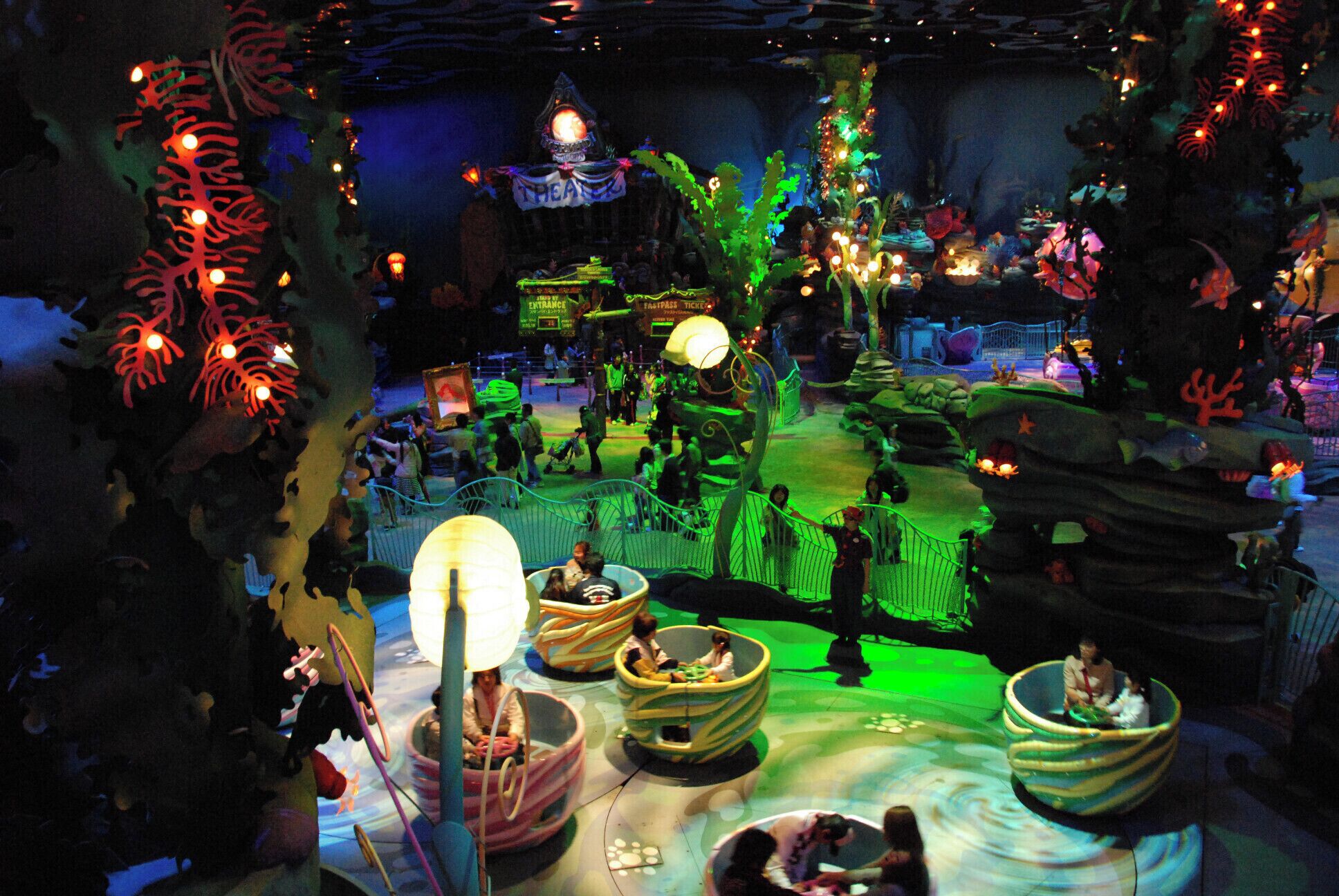 A themed indoor amusement park with a whimsical, fantasy setting, including a large tree, a castle, and various rides.