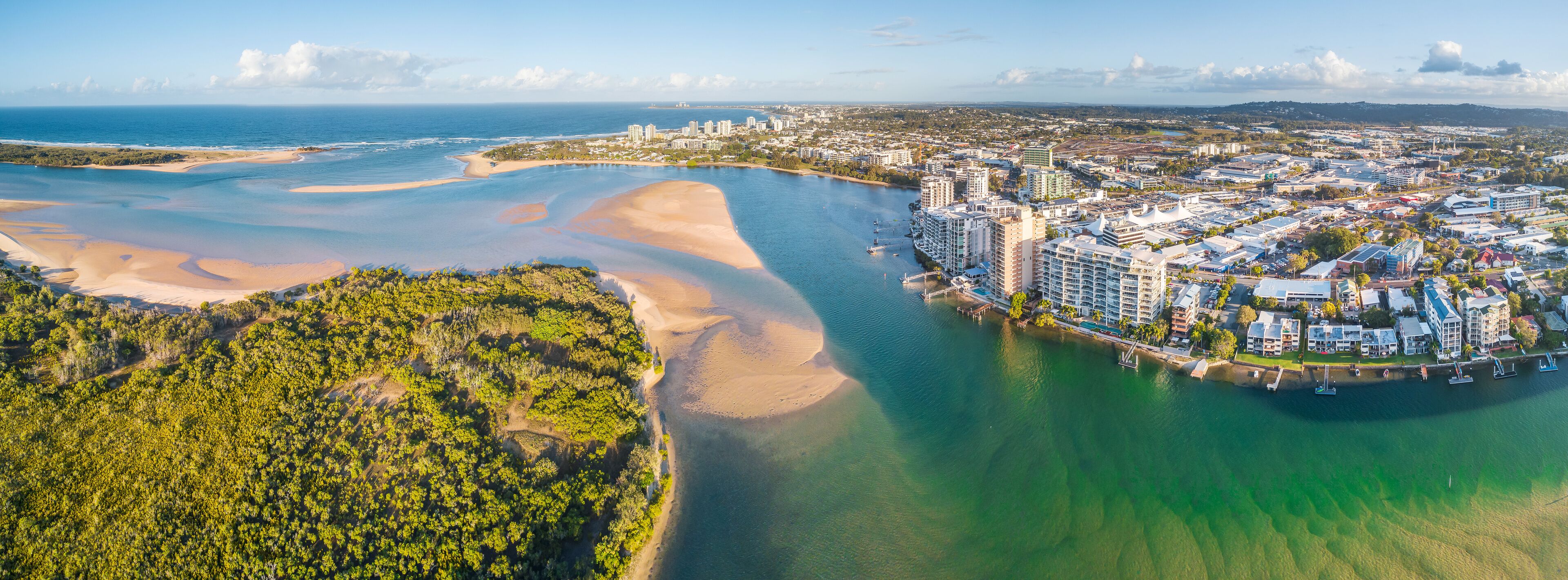 Panoramic aerial view of mangroves and real estate along the banks of the Maroochy River in Queensla