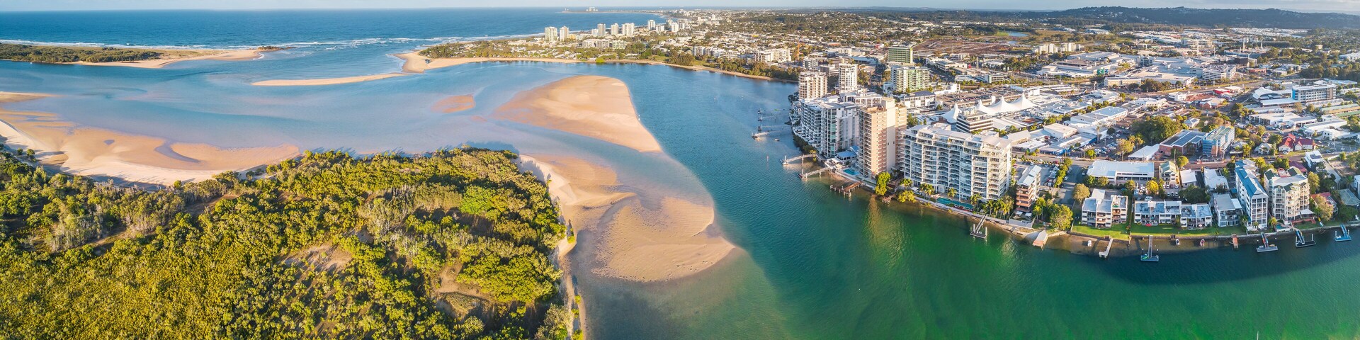 Panoramic aerial view of mangroves and real estate along the banks of the Maroochy River in Queensla