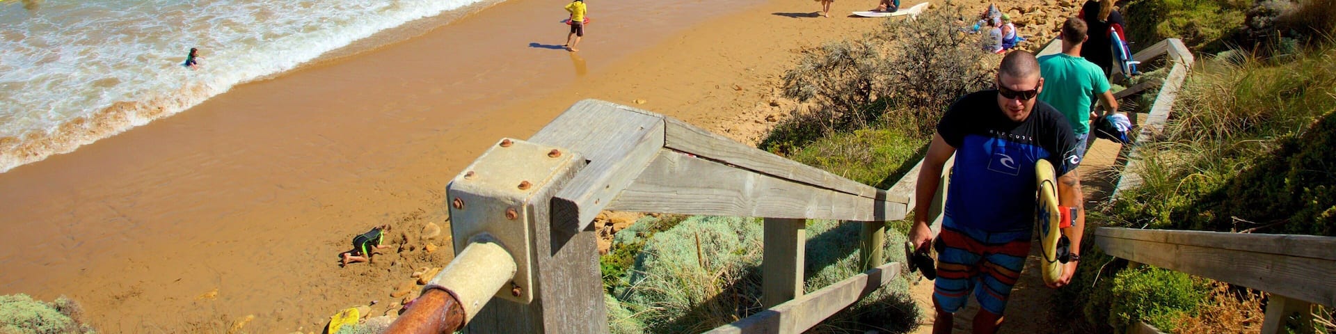 Torquay which includes a bay or harbour and a beach as well as a large group of people