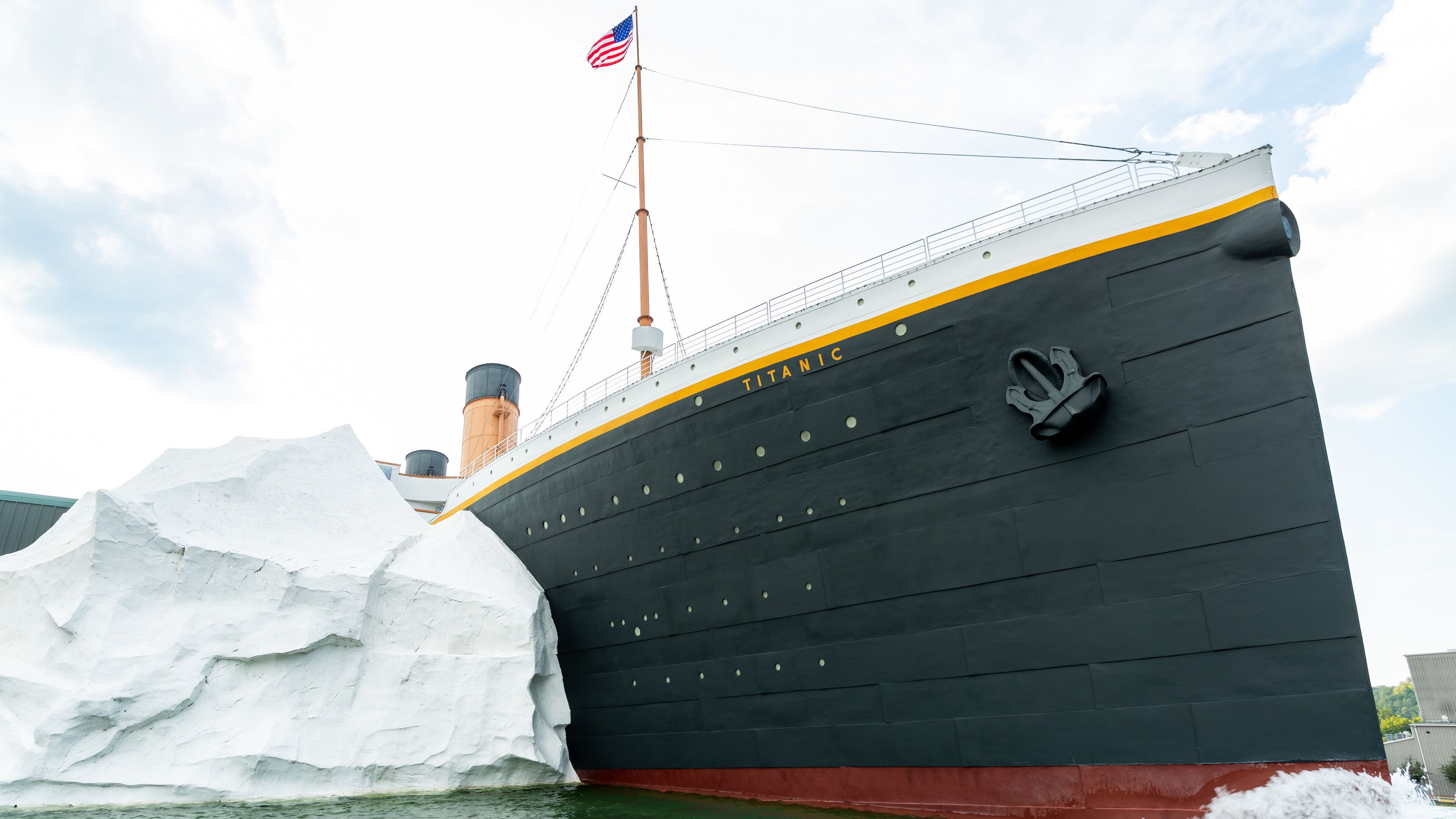 Una grande nave, il Titanic, con una bandiera americana, circondata da iceberg.