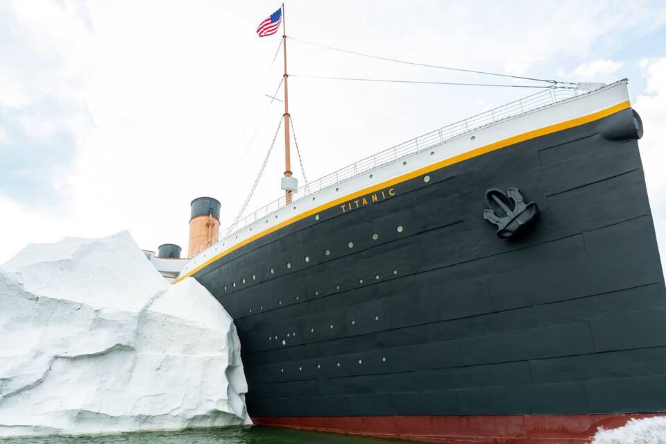 A large ship named Titanic with an American flag, surrounded by icebergs.