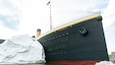 Un grand navire, le Titanic, arborant le drapeau américain, est entouré d’icebergs.