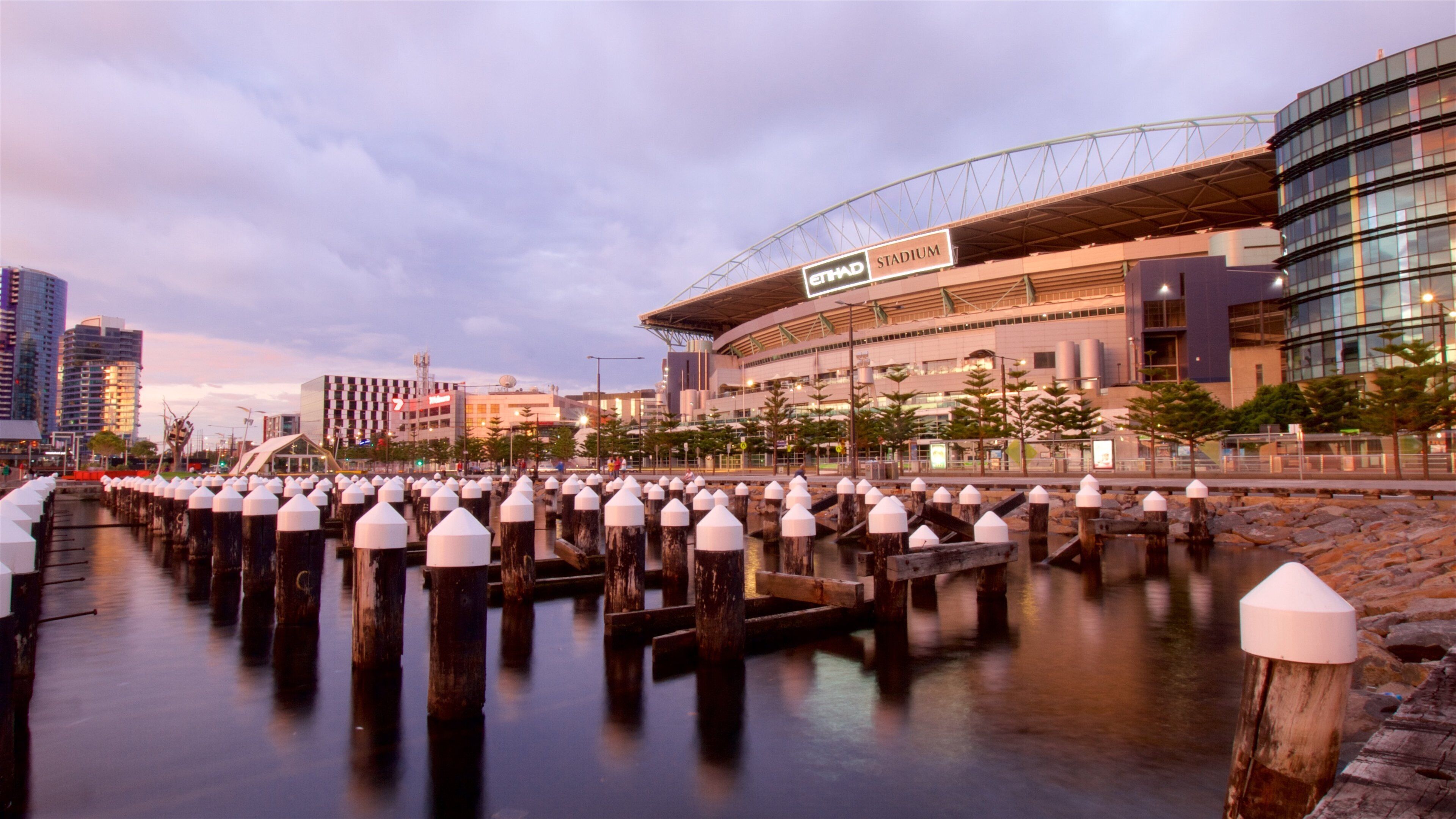 Una passeggiata sul lungomare con uno stadio moderno e edifici urbani.