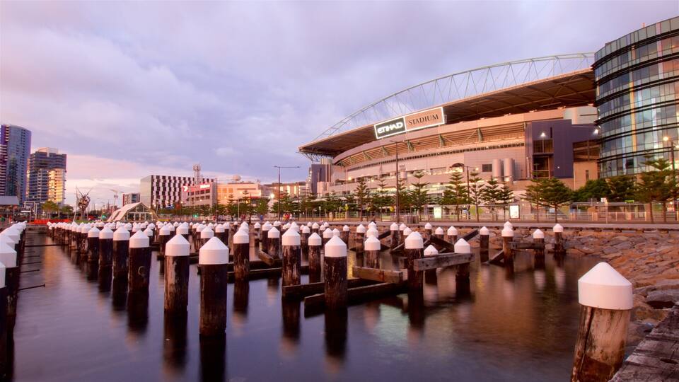 Una passeggiata sul lungomare con uno stadio moderno e edifici urbani.