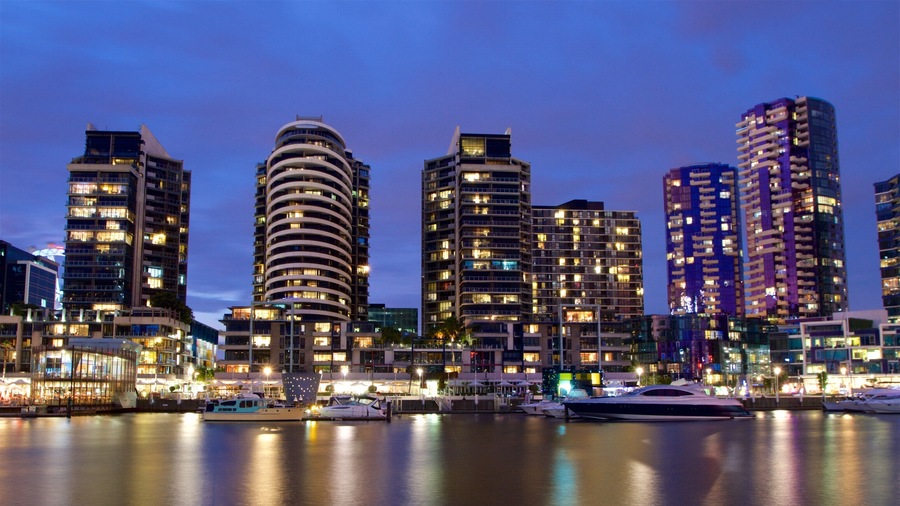 Docklands which includes a bay or harbour, night scenes and a high-rise building