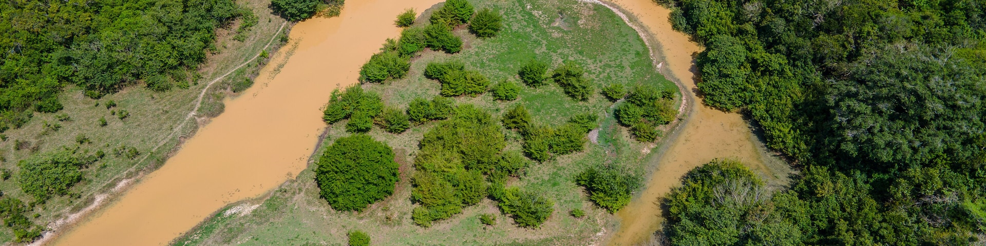 Aerial view of a winding river through lush green landscape at Hato La Aurora, Casanare, Colombia