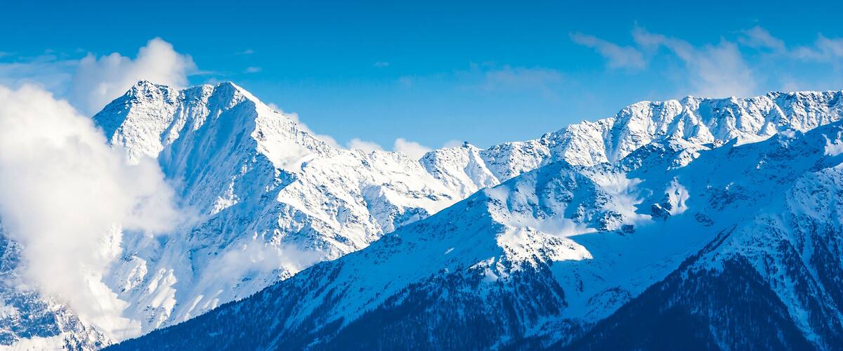 Snow-covered mountain peaks under a clear blue sky.