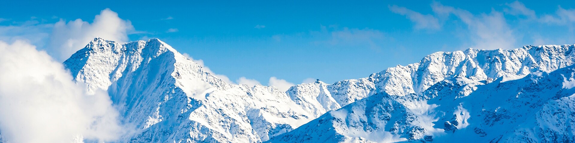 Snow-covered mountain peaks under a clear blue sky.