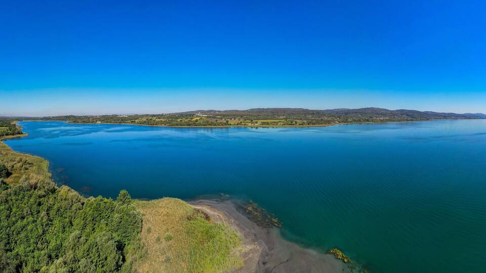 A large lake surrounded by mountains and dense forests.
