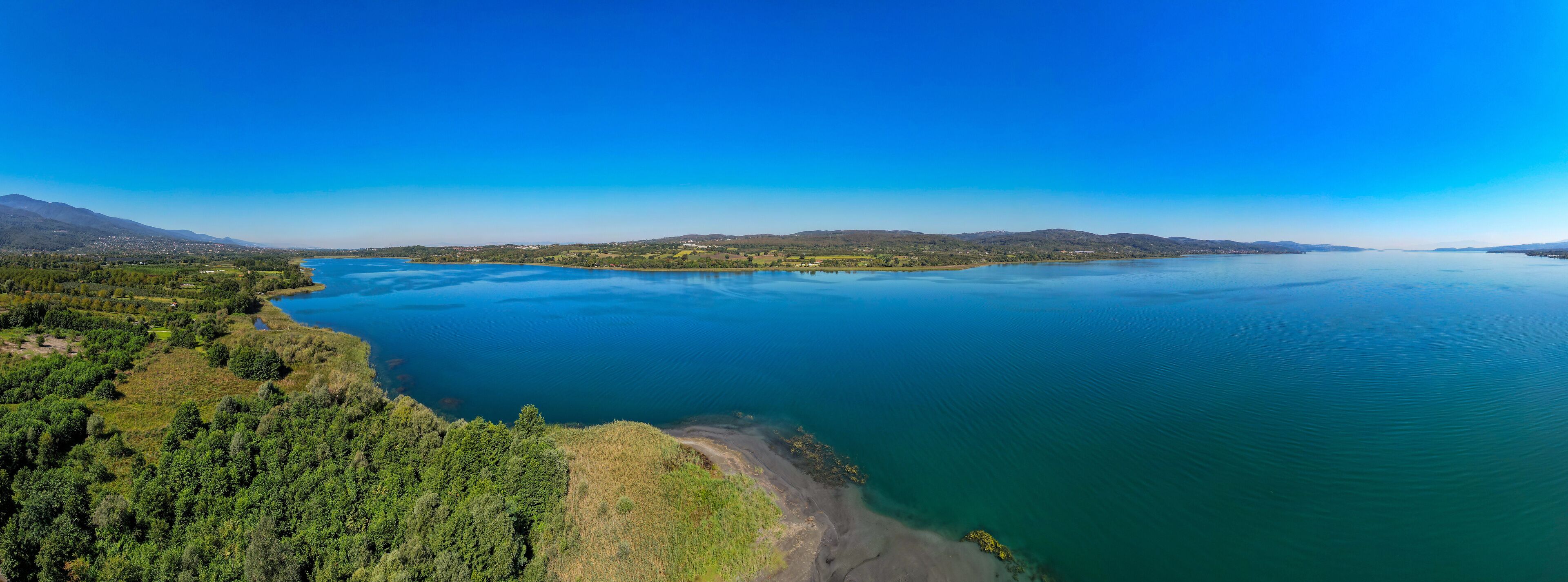A large lake surrounded by mountains and dense forests.