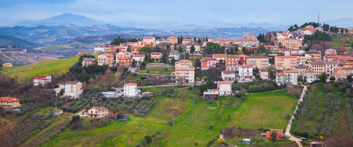 A hillside village with terraced houses and vineyards.