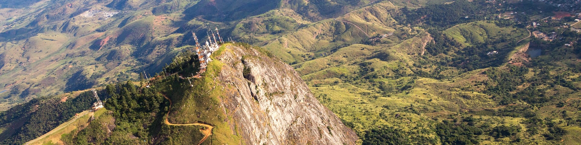 A mountainous landscape with a winding road and a large white building on a hilltop.