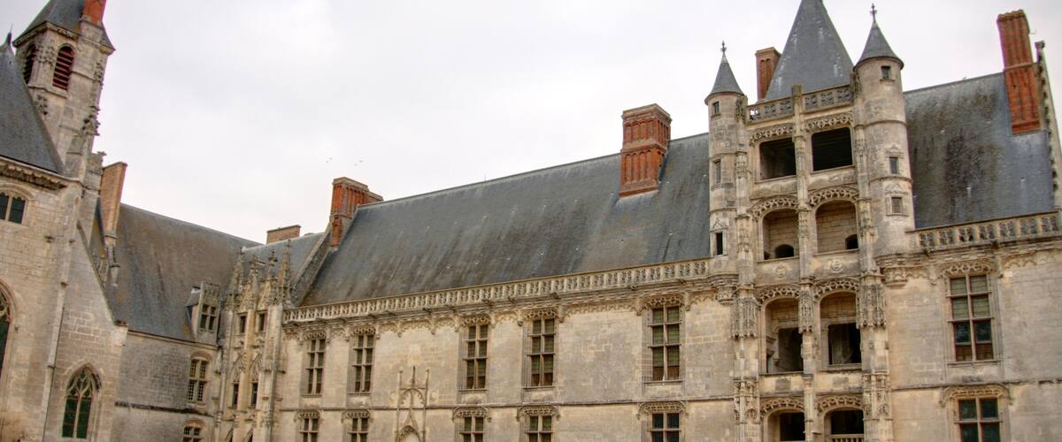A historic building with multiple towers and arched windows.