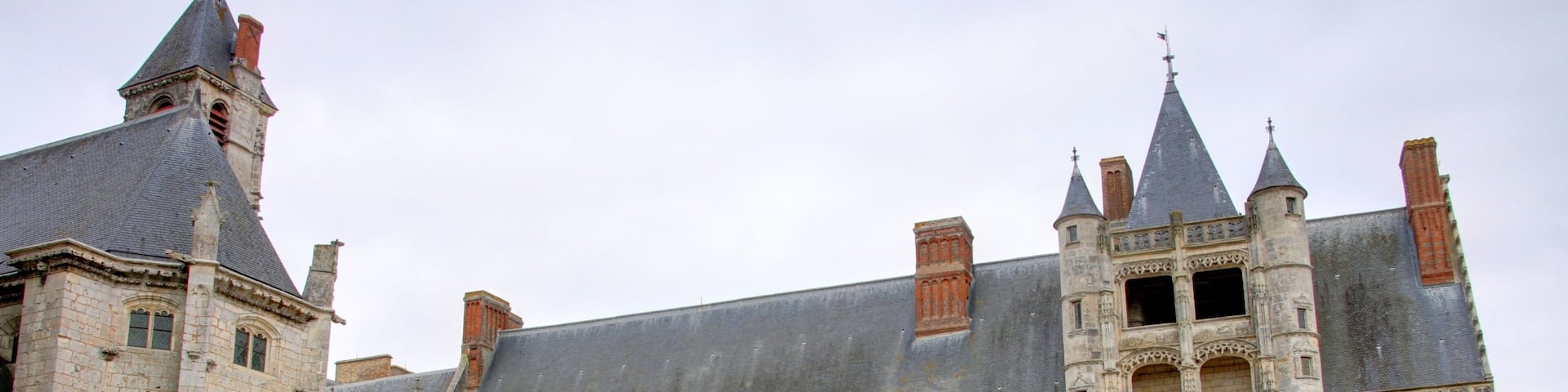 A historic castle with a large courtyard, tall towers, and intricate stonework.