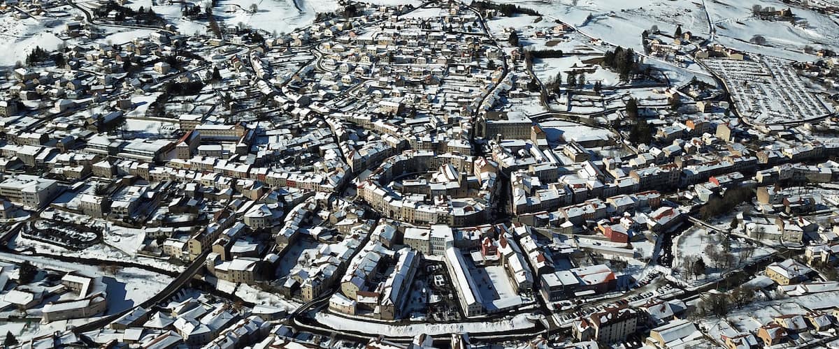 A snow-covered town with a lake and mountains in the background.