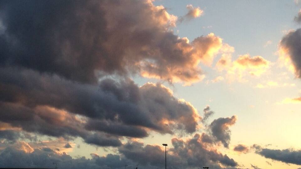 A sky with scattered clouds and a streetlight.