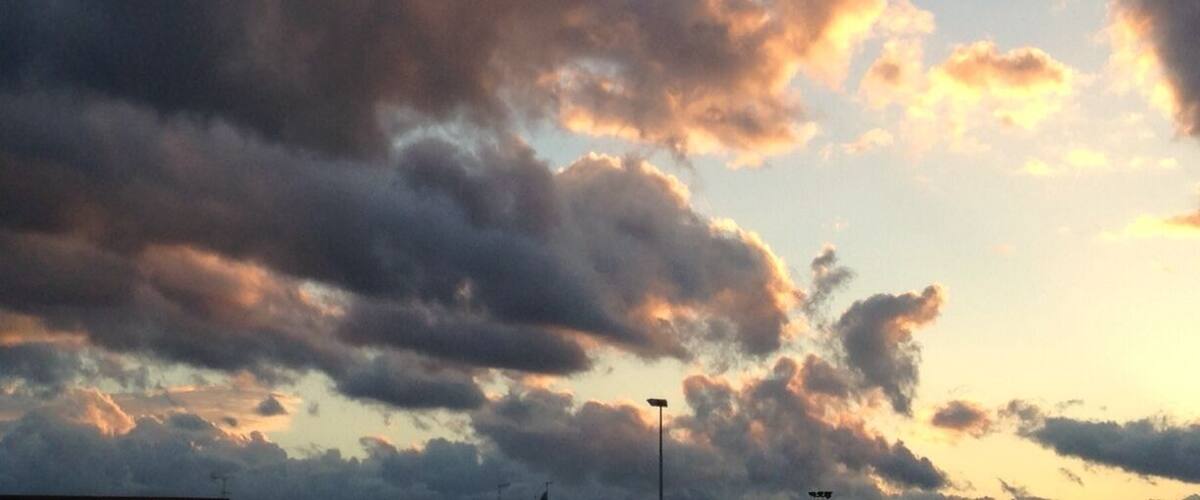 A sky with scattered clouds and a streetlight.