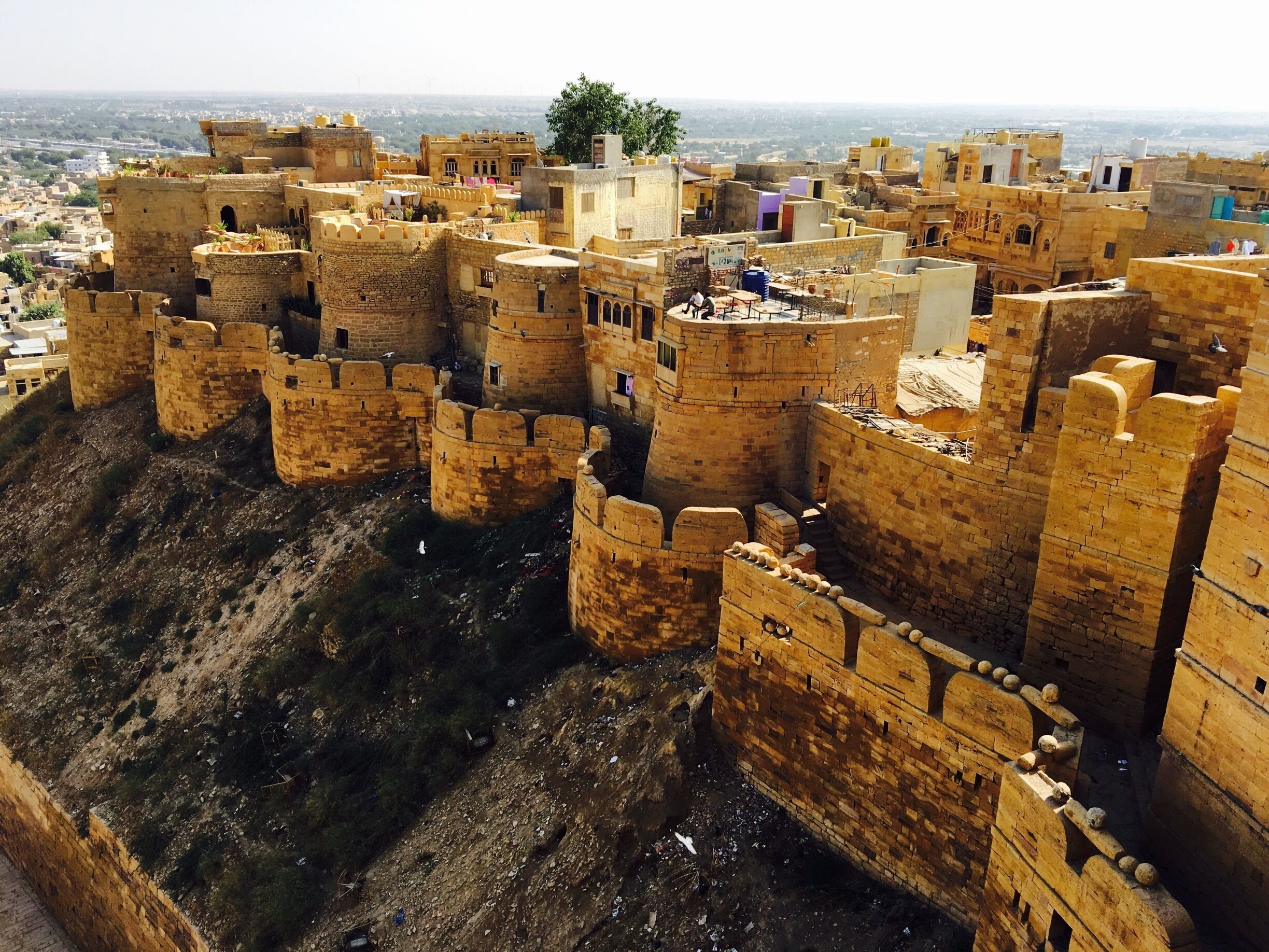 #StunningStructures #JaisalmerFort, Rajasthan,India... Jaisalmer Fort is one of the largest fully preserved fortified cities in the world. It is a World Heritage Site. It was built in 1156 AD by the Rajput ruler Rawal Jaisal. The fort stands amidst the sandy expanse of the great Thar Desert, on Trikuta Hill. The fort is 1,500 ft (460 m) long and 750 ft (230 m) wide and is built on a hill that raises above a height of 250 ft (76 m) above the surrounding country side. The basement of the fort has a 15 ft (4.6 m) tall wall forming a double line of defence. The bastions of the fort forms a chain about 30 ft (9.1 m). The fort has four entrances to the townside, one of which used to be guarded by cannon.