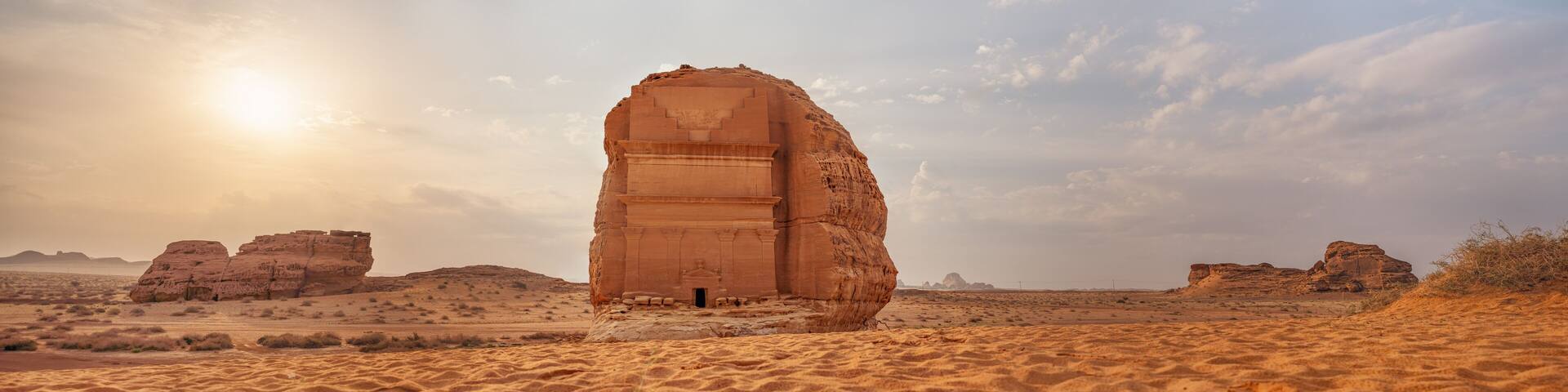 Tomb Lihyan Son of Kuza or Qasr al-Farid at Hegra, Saudia Arabia - most popular landmark in Mada'in Salih archaeological site, sandy desert landscape, morning sun background - high resolution panorama