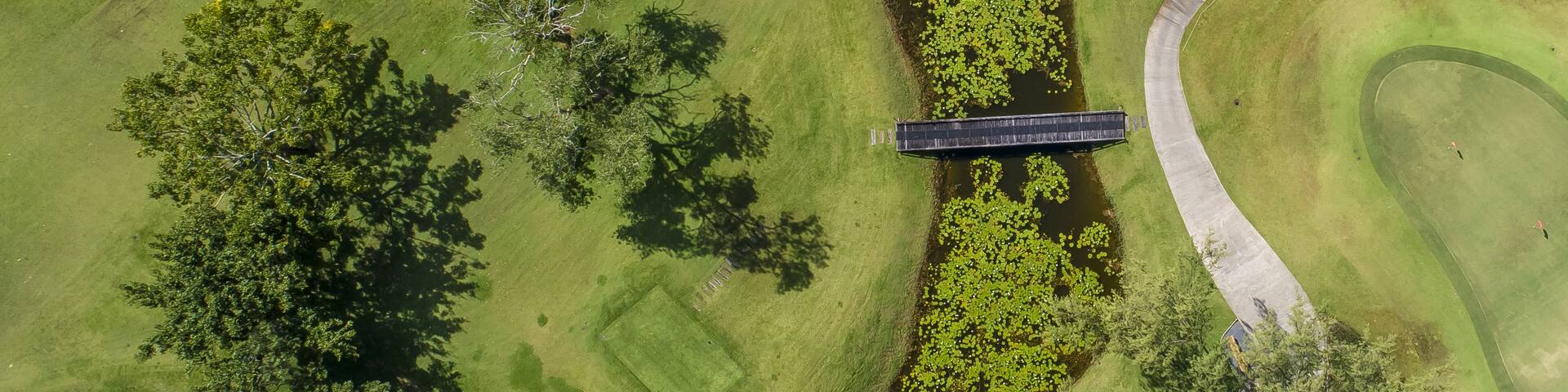 Golf course birds eye view of fairway golfing green sand pits lawn road house path no people copy space