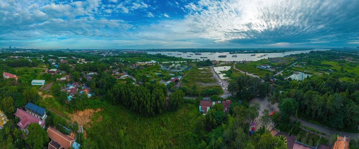High wide drone view of fish farming floating community and surrounds in Bien Hoa on the Dong Nai river in Vietnam on sunny day