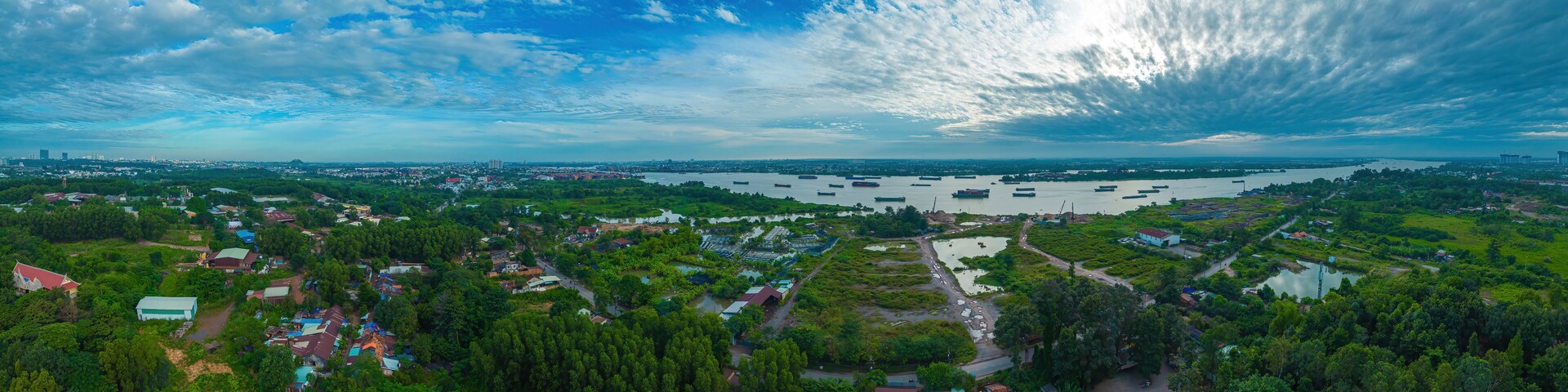 High wide drone view of fish farming floating community and surrounds in Bien Hoa on the Dong Nai river in Vietnam on sunny day
