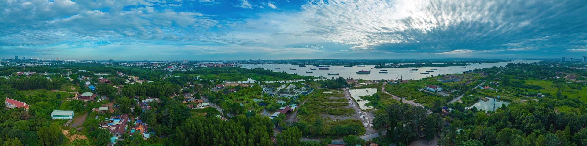 A coastal town with a river, boats, and green landscapes.
