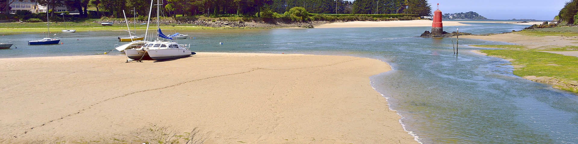 Beach in low tide with boats at Locquirec