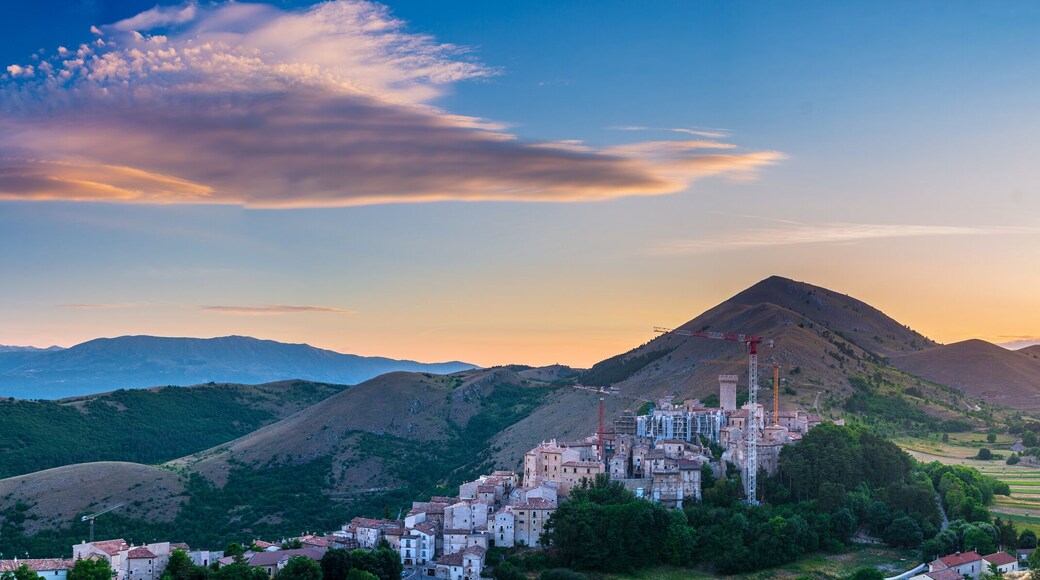 Sunset over medieval village perched on hill top, Santo Stefano di Sessanio, Abruzzo, Italy. Romantic sky and clouds above mountains landscape, tourism destination.