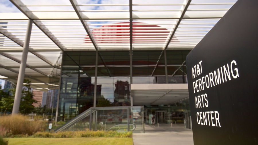 A modern building with a glass facade and a sign reading "AT&T Performing Arts Center".