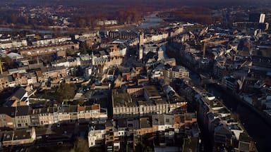 An aerial view of a densely built urban area with historic architecture, a river, and a bridge.