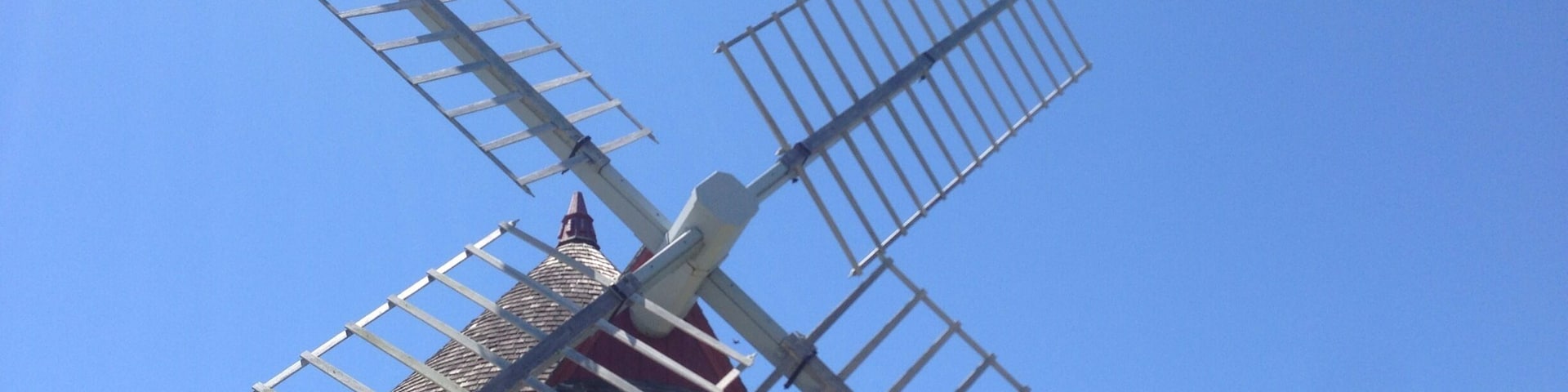 This is the Eastham Windmill in Eastham, MA on Cape Cod. It is the oldest windmill on Cape Cod, built in 1630. Every June there is an art festival held on the green by the windmill.