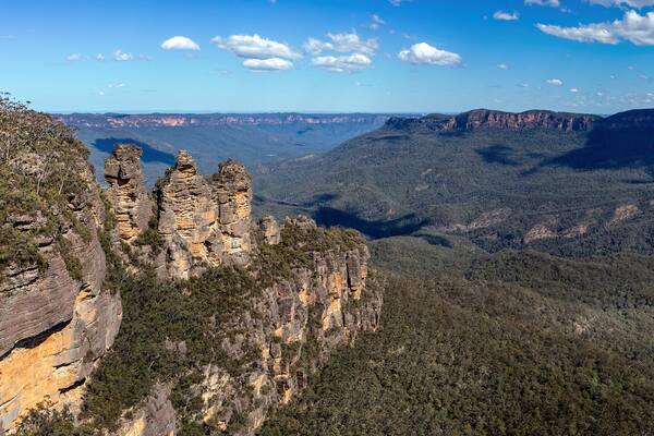 A canyon with prominent rock formations and dense forest.