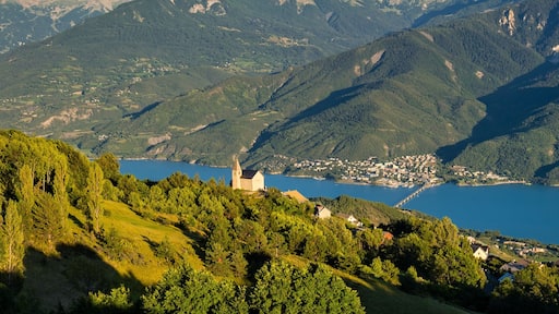 Elevated panoramic view on the Church of the village of Saint-Apollinaire and Savines-Le-Lac at sunset. Summer in the Hautes-Alpes, European Alps, France