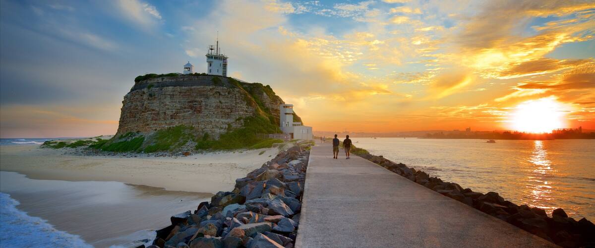 Newcastle East showing general coastal views and a sunset as well as a couple
