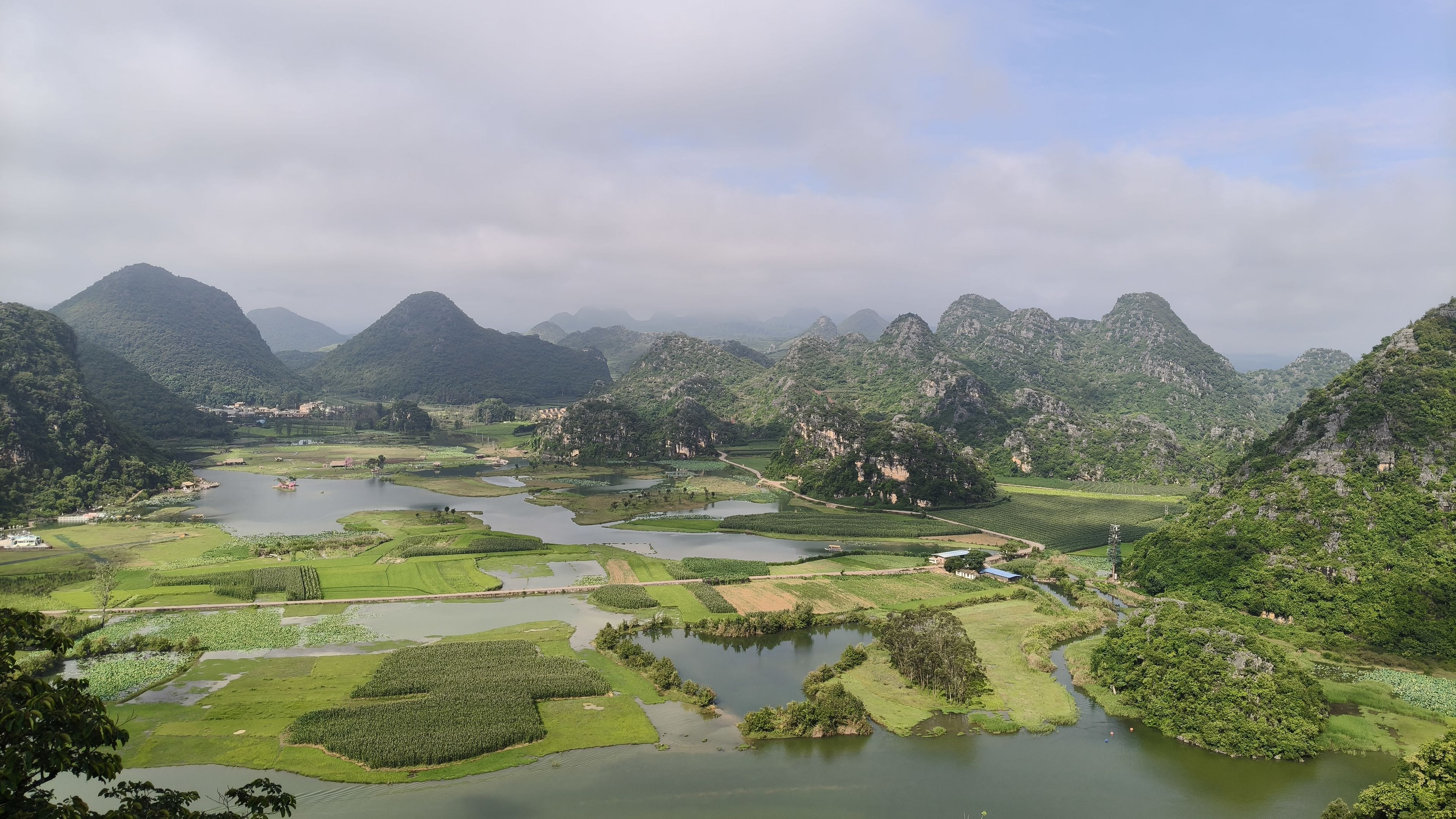 Un paysage montagneux avec des champs en terrasses et une rivière.