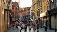 A busy urban street lined with historic buildings and shops.