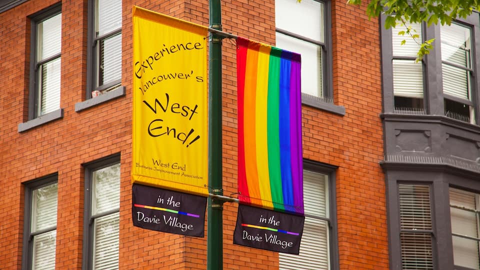 Un banner groc amb text negre que anuncia 'Experience Vancouver's West End' i una bandera arc de color.