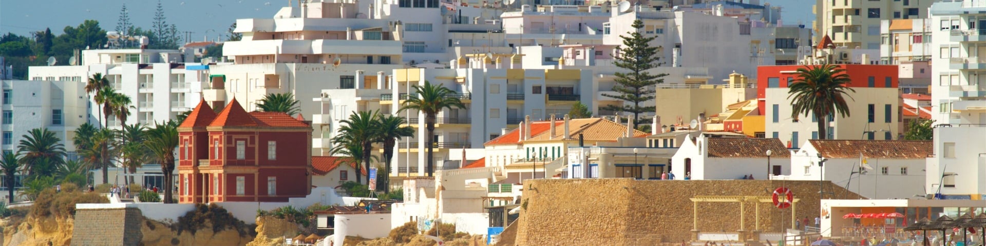 Salgados Beach showing a sandy beach, waves and a city