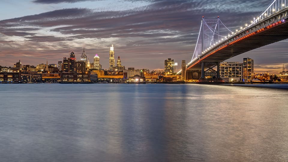 A city skyline with a prominent bridge spanning a body of water.
