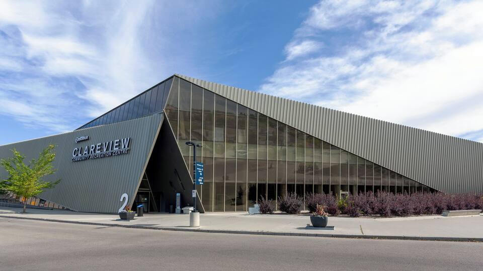A modern community recreation center with a distinctive triangular roof and large glass windows.