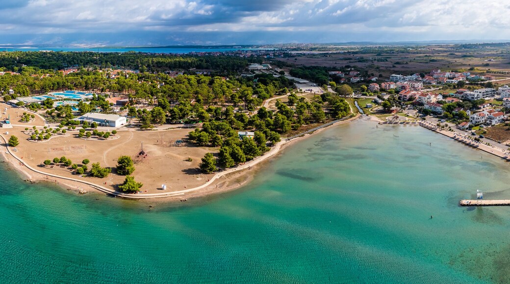 Zaton, Croatia - Aerial wide panoramic view of Zaton tourist waterfront with turquoise sea water, Nin village and Velebit mountains at background on a sunny summer day in Dalmatia region of Croatia