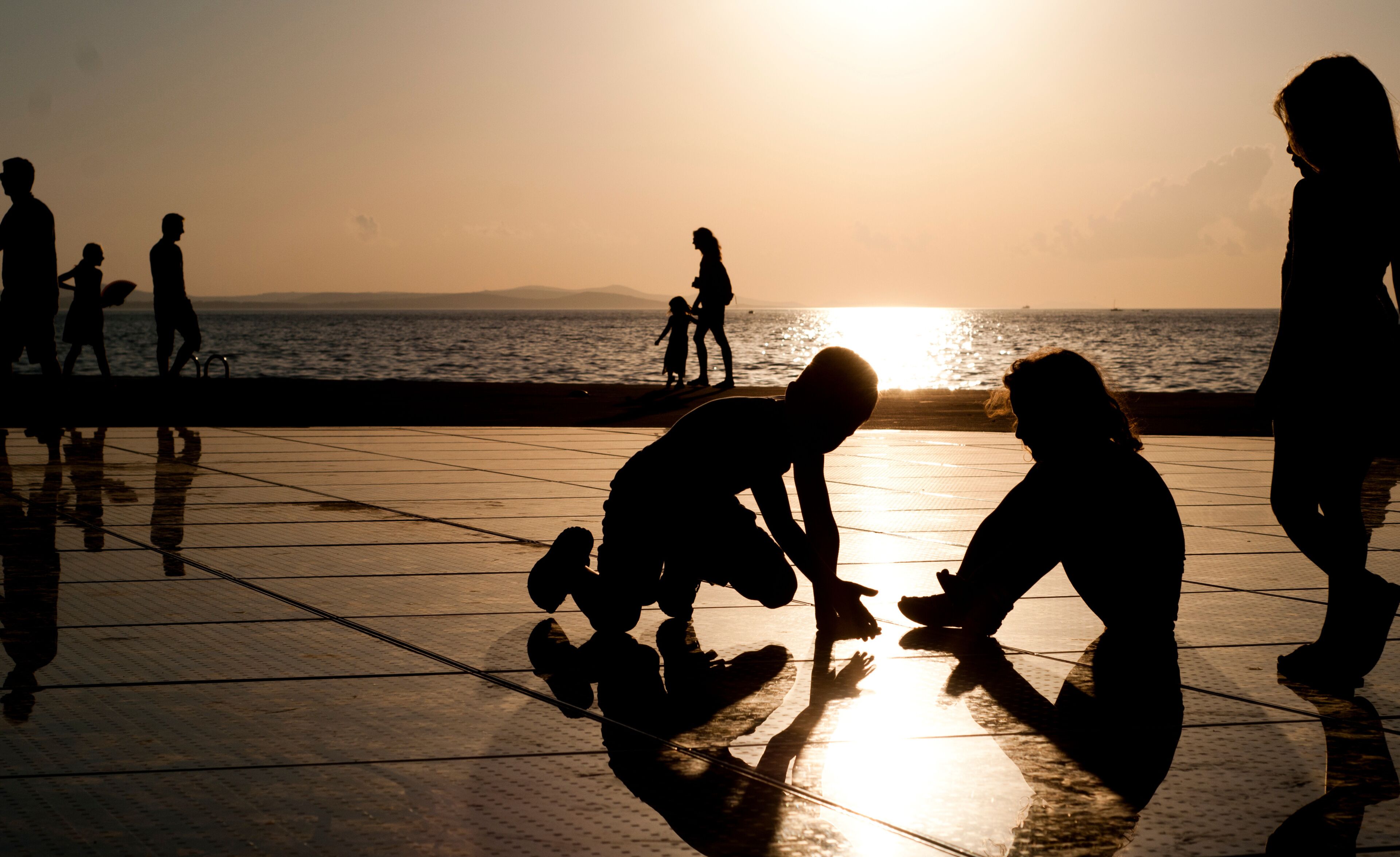 People silhouette reflections at "The Greeting to the Sun" solar