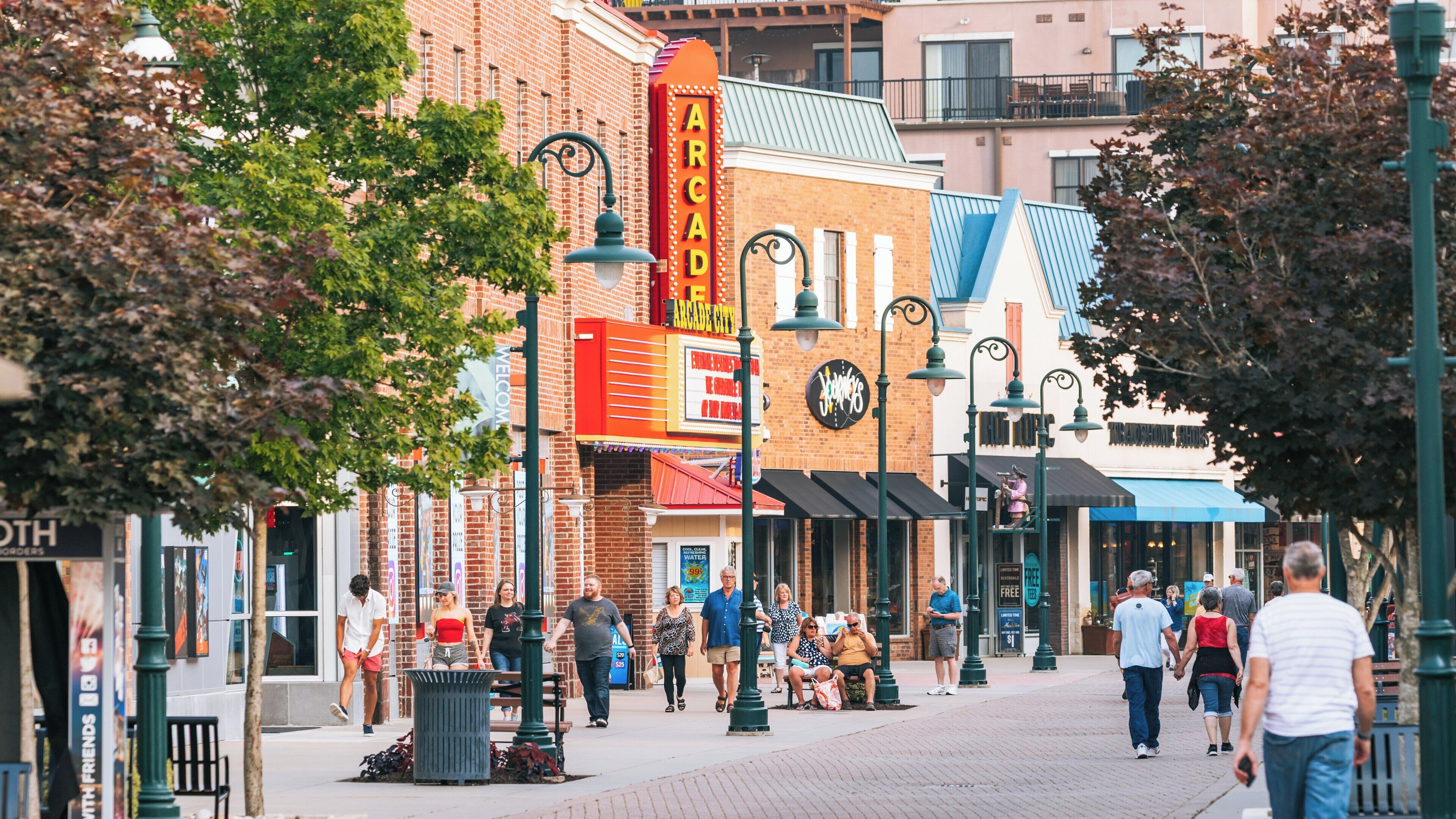 Visitors stroll along Branson Landing in downtown Branson Missouri enjoying shops, dining, and entertainment on a sunny day