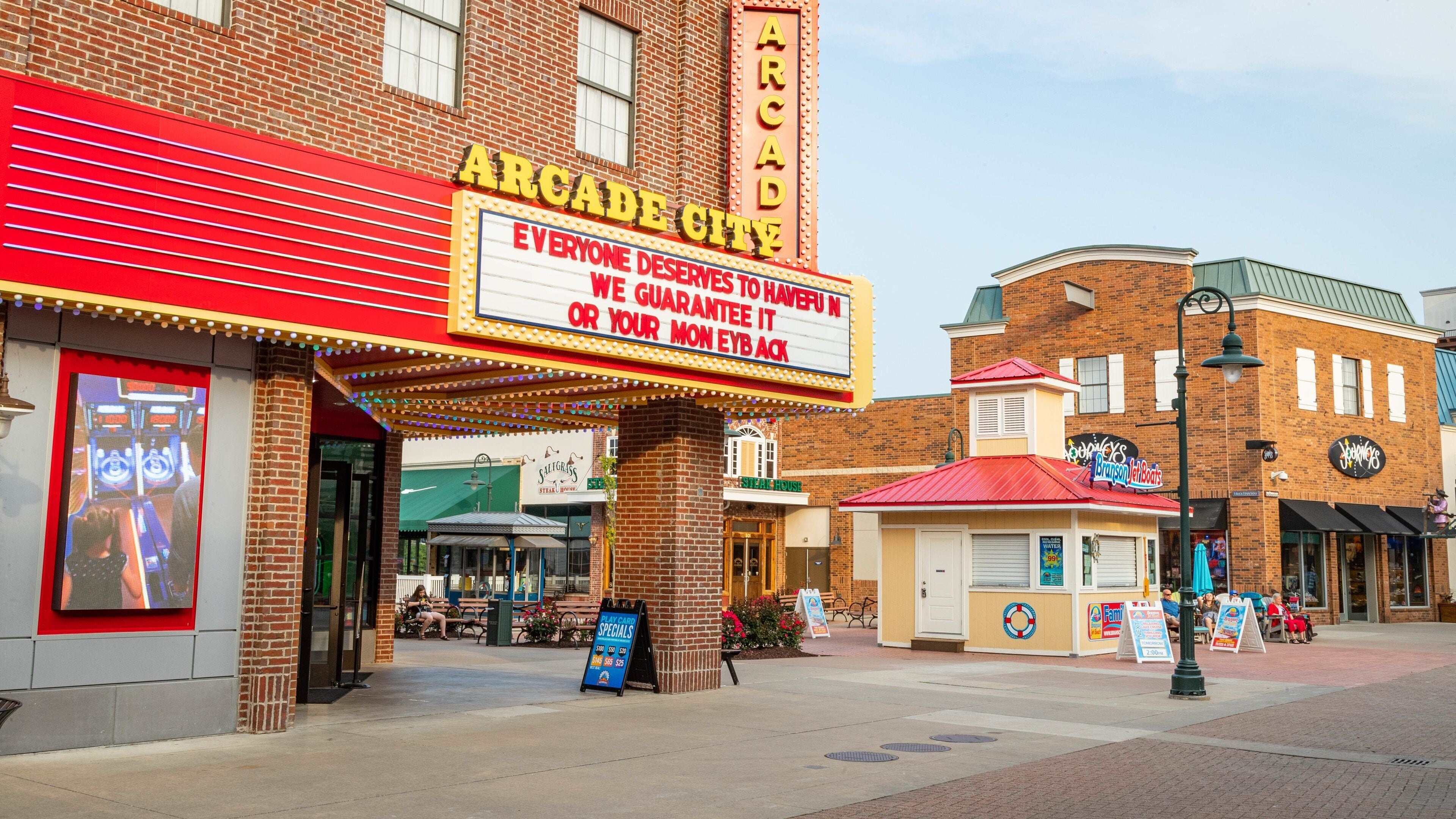 A brick building with a marquee that reads "Arcade City" and a sign that says "Everyone deserves to have fun, we guarantee it or your money back."