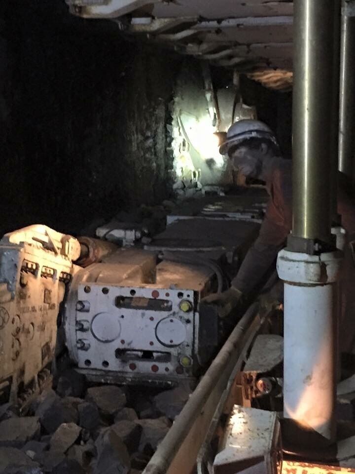 A mining operation with heavy machinery and workers in protective gear.