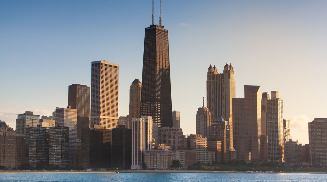 Chicago Illinois city sunset skyline and cityscape from Lake Michigan with John Hancock Building in the center. Evening light in the summer from sailboat at the playpen.