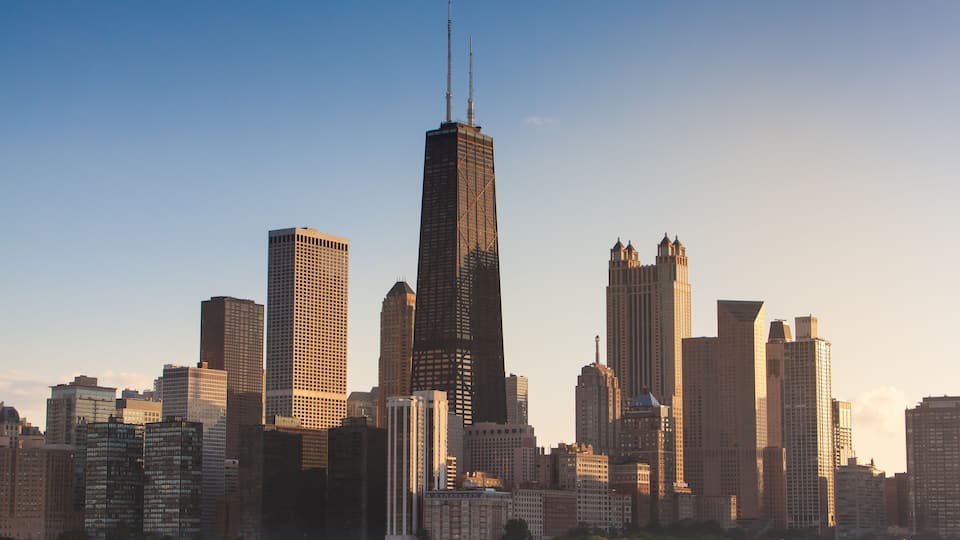 A city skyline with a prominent skyscraper and several other high-rise buildings.